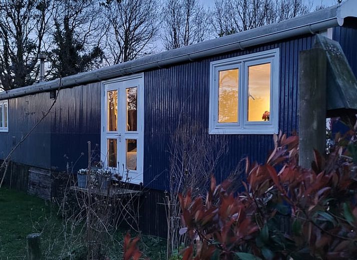 Ferienhaus in Basse, im Nordwesten von Overijssel, umgeben von gruener Natur und bunten Blumentoepfen.