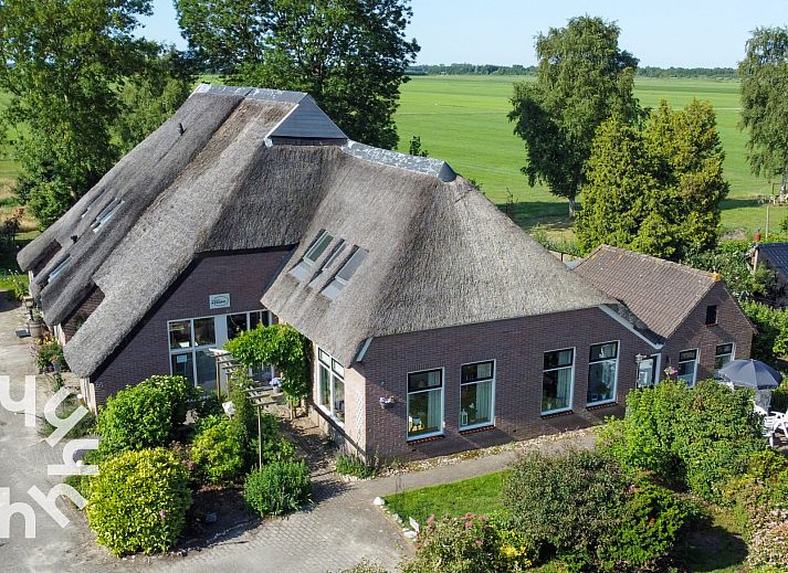 Luchtfoto van OV517, een charmant vakantiehuis in Zuidveen, Noordwest Overijssel, omgeven door groene velden.