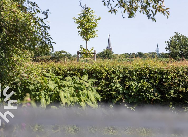 Historische kerktoren in de buurt van OV517 vakantiehuis in Zuidveen, omgeven door groen en rust.