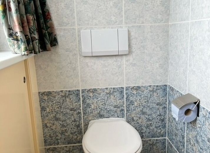 Eingang des Ferienhauses Marie Loosdrecht in Loosdrecht, Utrecht, mit gruenen Akzenten und einem Kunstwerk an der Wand.