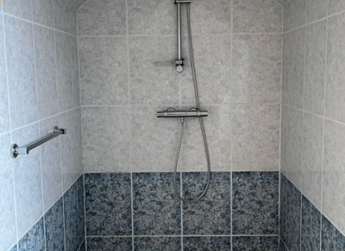 Eingang des Ferienhauses Marie Loosdrecht in Loosdrecht, Utrecht, mit gruenen Akzenten und einem Kunstwerk an der Wand.