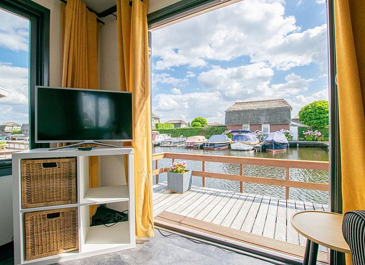 Blauwborst 24-20 vakantiehuis in Breukelen met terras aan het water en aangemeerde boten.