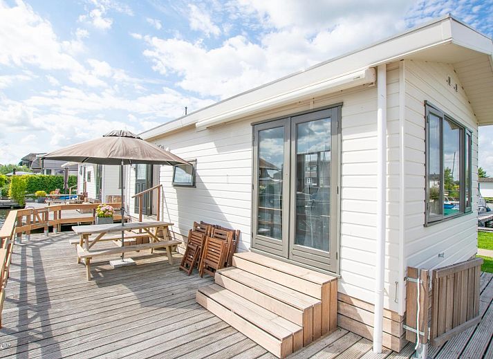 Terras met parasol en bloemen bij Blauwborst 24-20 vakantiehuis in Breukelen, Utrecht.
