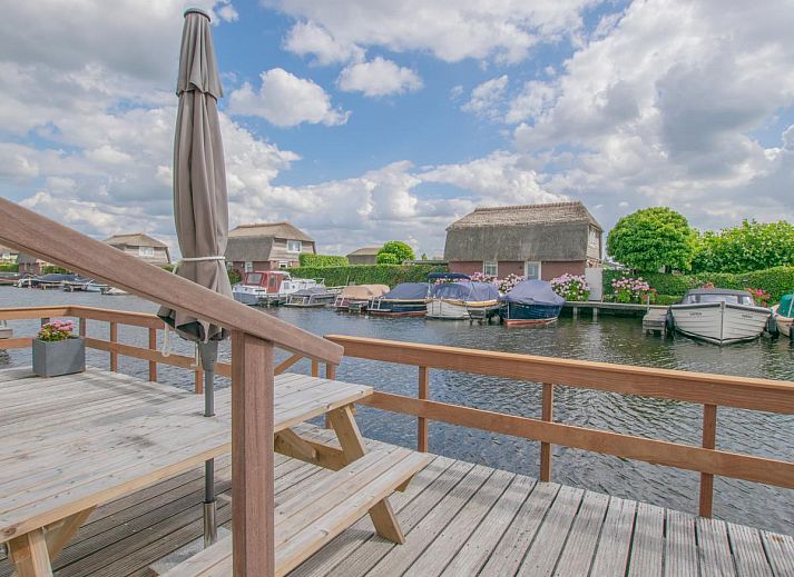 Terras met parasol en bloemen bij Blauwborst 24-20 vakantiehuis in Breukelen, Utrecht.