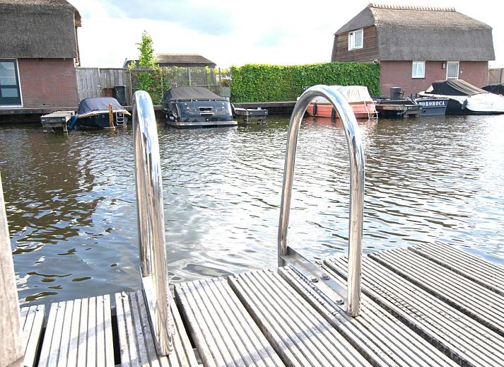 Terras met parasol en bloemen bij Blauwborst 24-20 vakantiehuis in Breukelen, Utrecht.