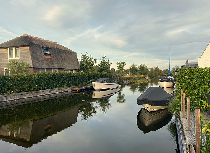 Geniessen Sie die sonnige Terrasse des Ferienhauses UT096 in Breukelen, Utrecht, mit bequemen Sitzgelegenheiten und Blick auf die gruene Umgebung.