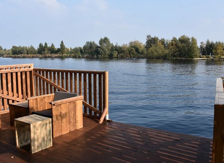 Geniessen Sie die Aussicht von der Terrasse des Huisje in Vinkeveen, einem Ferienhaus in Vinkeveen, Utrecht, umgeben von schoener Natur.