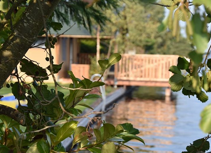 Stilvoller Innenraum des Huisje in Vinkeveen, Ferienhaus in Utrecht, mit moderner Beleuchtung und Blick auf die gruene Natur.
