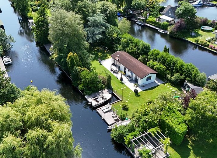 Luchtfoto van Huisje in Vinkeveen, vakantiehuis in Utrecht met groene omgeving en waterkanalen.