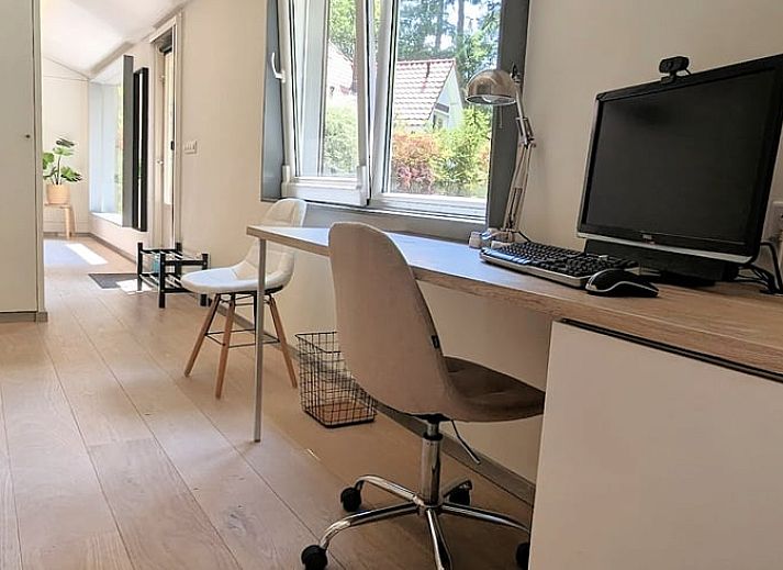 Stijlvolle woonkamer in Vakantiehuis in Soest met uitzicht op de groene natuur van Utrecht.