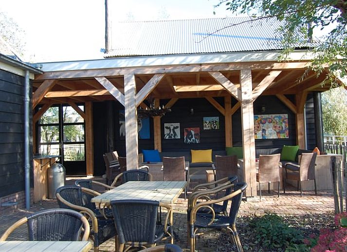 Comfortabele slaapkamer in Vakantiehuis in Vreeland, Utrecht, met groene accenten en kunst aan de muur.