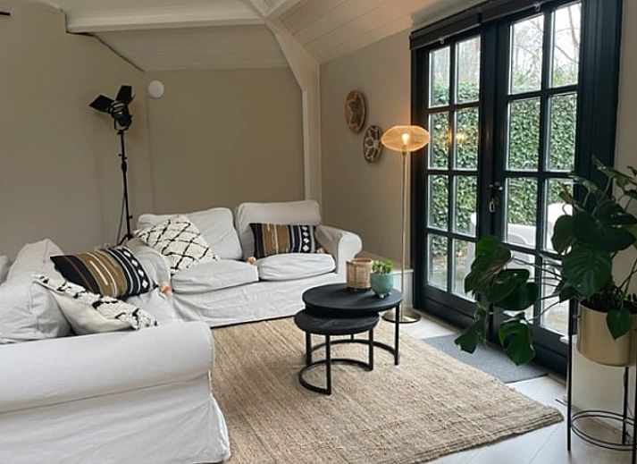 Gezellig terras bij Huisje in Tienhoven, vakantiehuis in Tienhoven, Utrecht, met uitzicht op groene tuin en bloemen.