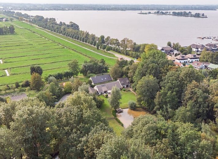 Gezellig terras bij Huisje in Tienhoven, vakantiehuis in Tienhoven, Utrecht, met uitzicht op groene tuin en bloemen.
