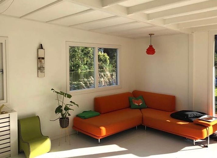 Veranda van Vakantiehuisje in Tienhoven met uitzicht op de serene vijver in Utrecht noord.