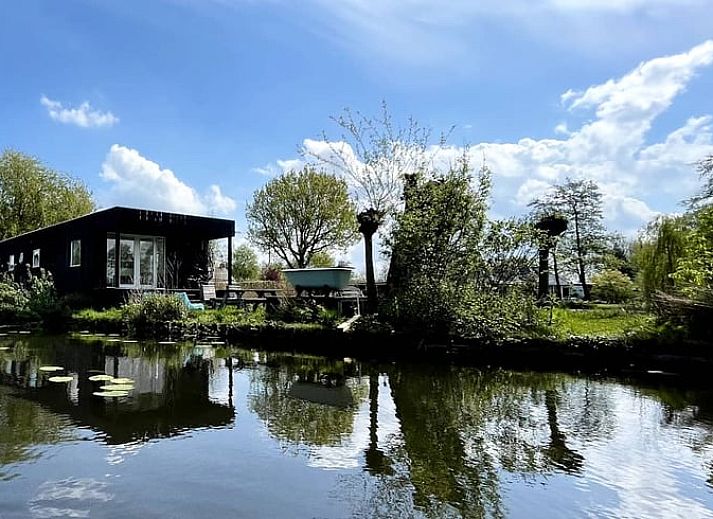 Lichte binnenruimte van Vakantiehuisje in Tienhoven in Utrecht noord met terraszicht.