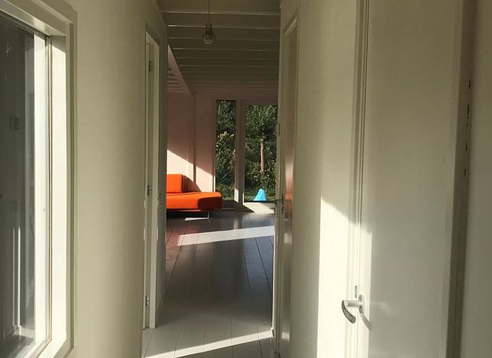 Binnenruimte van Vakantiehuisje in Tienhoven met boekenkast en uitzicht op de vijver in Utrecht noord.