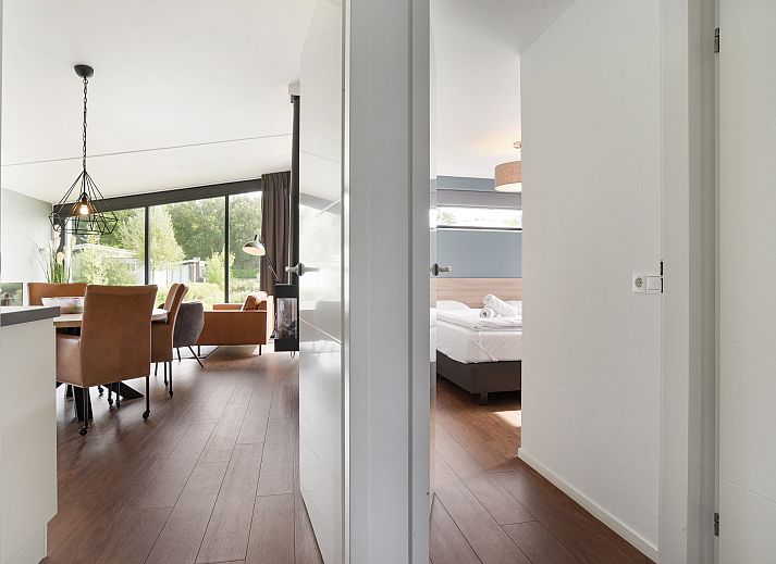 Gezellige woonkamer van Amerongse Berg 4-persoons woning 4EL1 in Overberg met tuinzicht en stijlvolle inrichting.