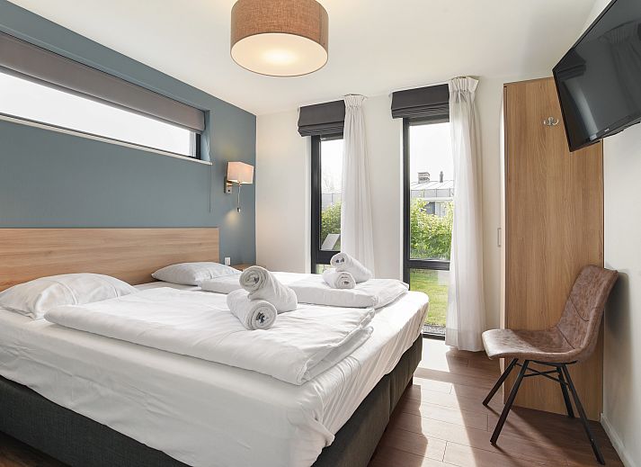 Gezellige woonkamer van Amerongse Berg 4-persoons woning 4EL1 in Overberg met tuinzicht en stijlvolle inrichting.