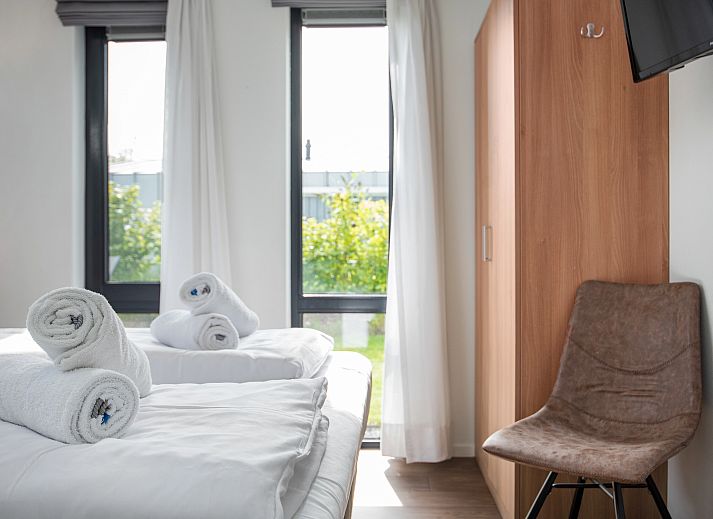 Gezellige woonkamer van Amerongse Berg 4-persoons woning 4EL1 in Overberg met tuinzicht en stijlvolle inrichting.