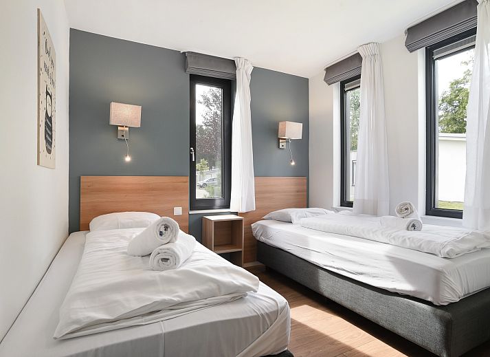 Gezellige woonkamer van Amerongse Berg 4-persoons woning 4EL1 in Overberg met tuinzicht en stijlvolle inrichting.