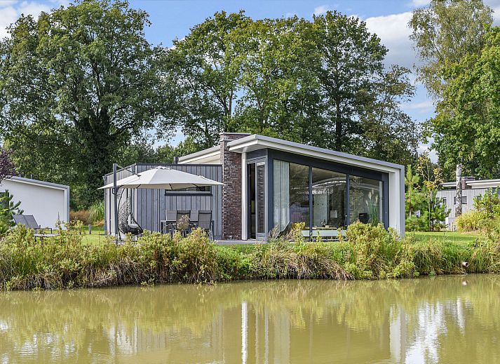 Moderne zithoek in Amerongse Berg 4-persoons woning 4EL1, Overberg, met uitzicht op de groene omgeving.