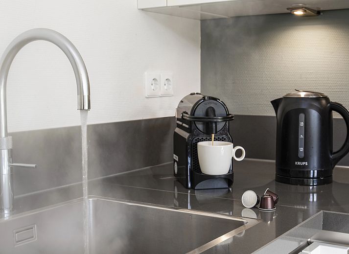 Stijlvolle woonkamer van Amerongse Berg 4-persoons woning 4EL1 in Overberg met uitzicht op de tuin.