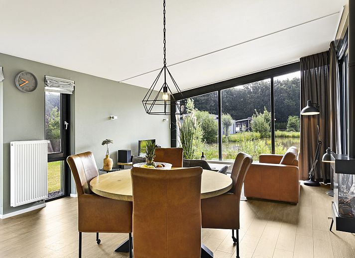 Stijlvolle woonkamer van Amerongse Berg 4-persoons woning 4EL1 in Overberg met uitzicht op de tuin.