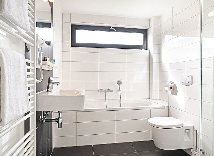 Gezellige woonkamer in Amerongse Berg vakantiehuis in Overberg, Utrechtse Heuvelrug, met comfortabele zitplaatsen.