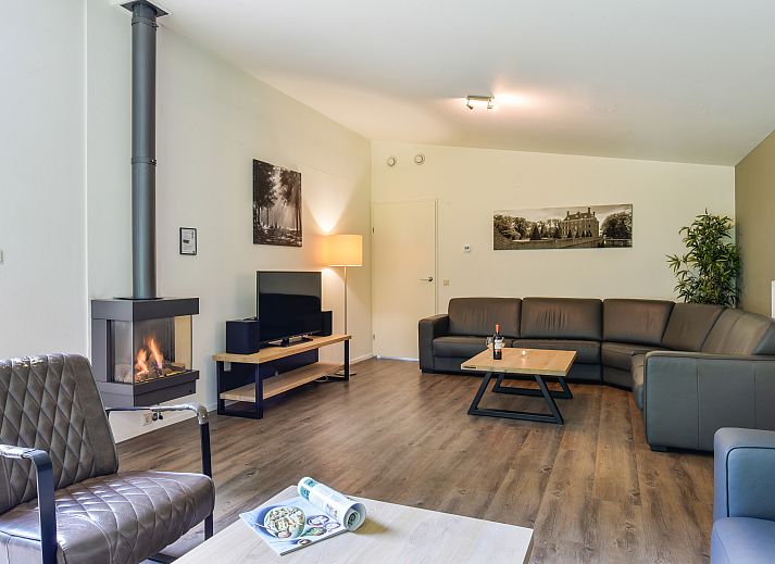 Moderne zithoek met open haard in Amerongse Berg vakantiehuis in Overberg, Utrechtse Heuvelrug, Utrecht.