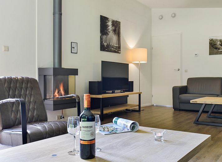 Moderne zithoek met open haard in Amerongse Berg vakantiehuis in Overberg, Utrechtse Heuvelrug, Utrecht.