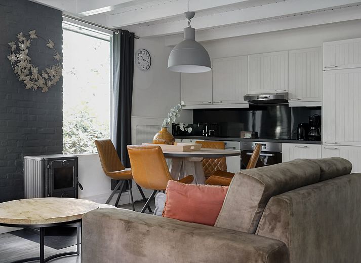 Entspannen Sie sich auf der ueberdachten Veranda des Bungalows Schoonoord in Doorn, Utrechtse Heuvelrug, mit Blick auf die gruene Umgebung.