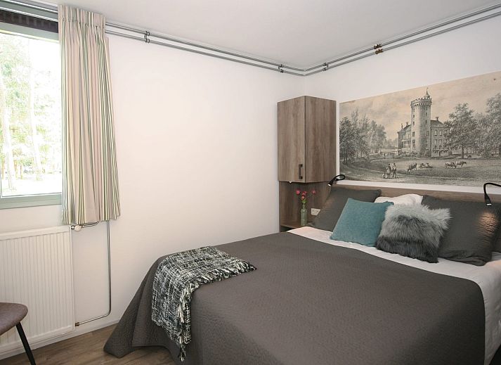 Terras met parasol bij Aangepaste bungalow Sterkenburg, vakantiehuis in Doorn, Utrechtse Heuvelrug, omringd door natuur.