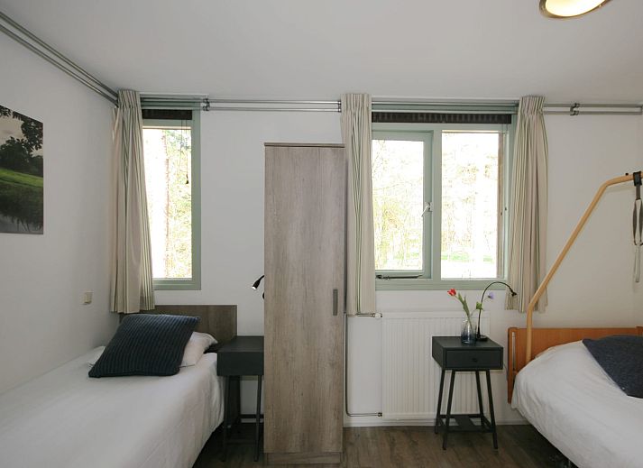 Terras met parasol bij Aangepaste bungalow Sterkenburg, vakantiehuis in Doorn, Utrechtse Heuvelrug, omringd door natuur.