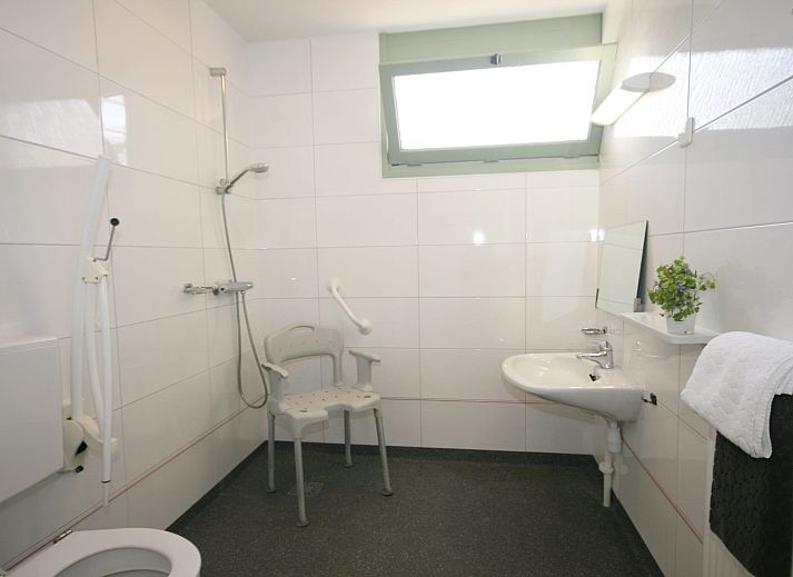 Terras met parasol bij Aangepaste bungalow Sterkenburg, vakantiehuis in Doorn, Utrechtse Heuvelrug, omringd door natuur.