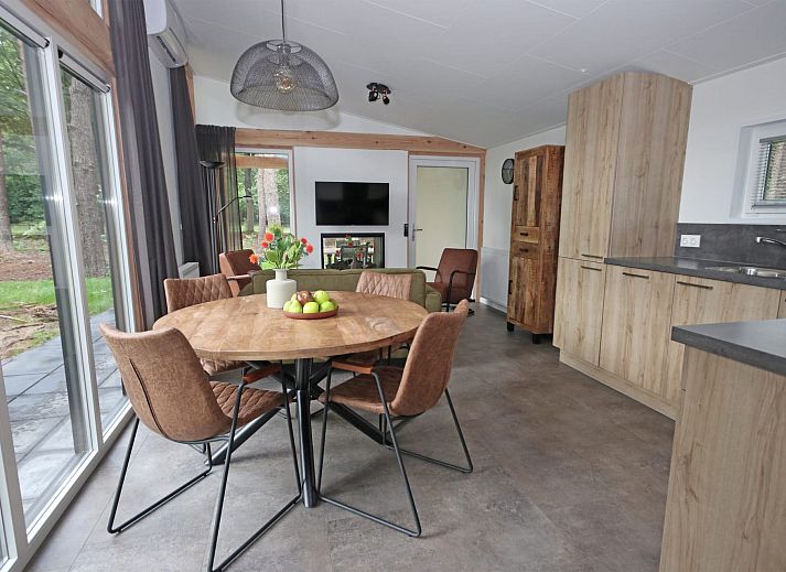 Geniet van de rust op het terras van Bungalow Molenstein, een vakantiehuis in Doorn, Utrechtse Heuvelrug, omgeven door groene natuur.