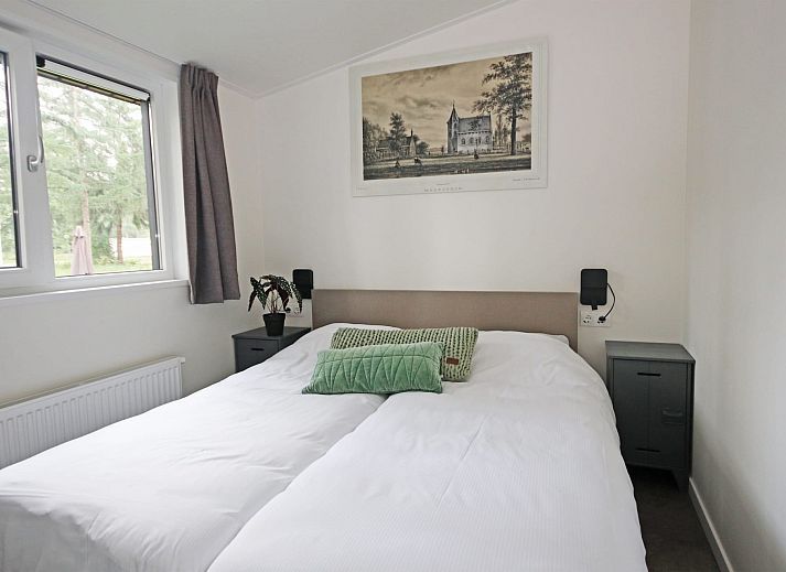 Geniet van de rust op het terras van Bungalow Molenstein, een vakantiehuis in Doorn, Utrechtse Heuvelrug, omgeven door groene natuur.