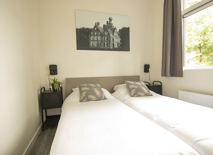 Gemuetliches Wohnzimmer des Bungalows Zuylestein in Doorn mit komfortablen Moebeln und Blick auf die Natur.