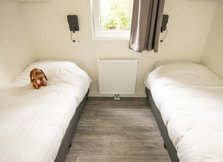 Gemuetliches Wohnzimmer des Bungalows Zuylestein in Doorn mit komfortablen Moebeln und Blick auf die Natur.