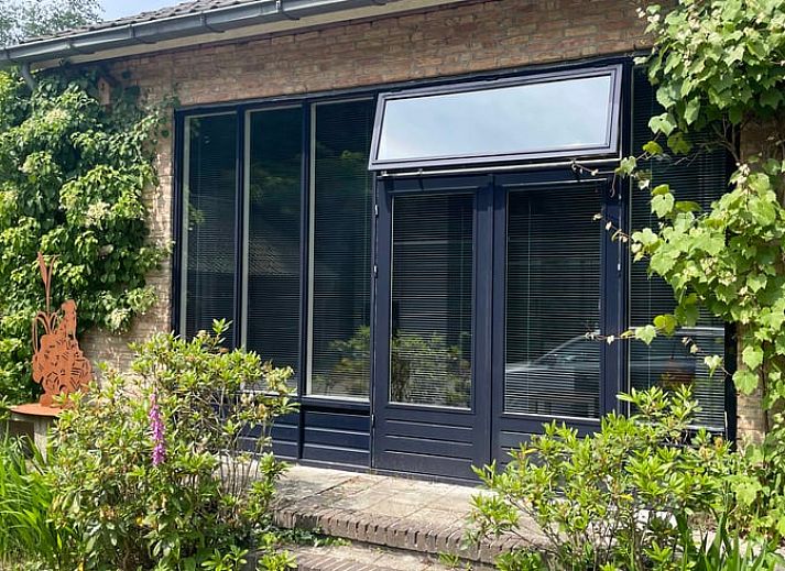 Ferienhaus in Doorn mit gruener Fassade auf dem Utrechter Bergruecken.