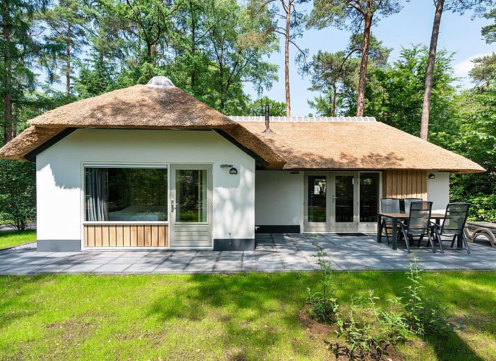 Bungalow Dennenburg in Doorn, Utrechtse Heuvelrug with thatched roof and terrace in green surroundings.