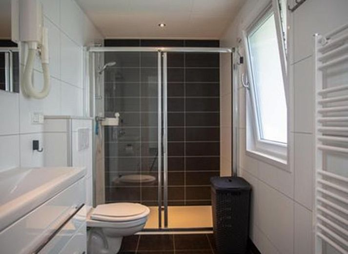 Eetkamer van Vakantiehuis De Thijmse Berg in Rhenen, Utrechtse Heuvelrug, met moderne inrichting en uitzicht op de tuin.