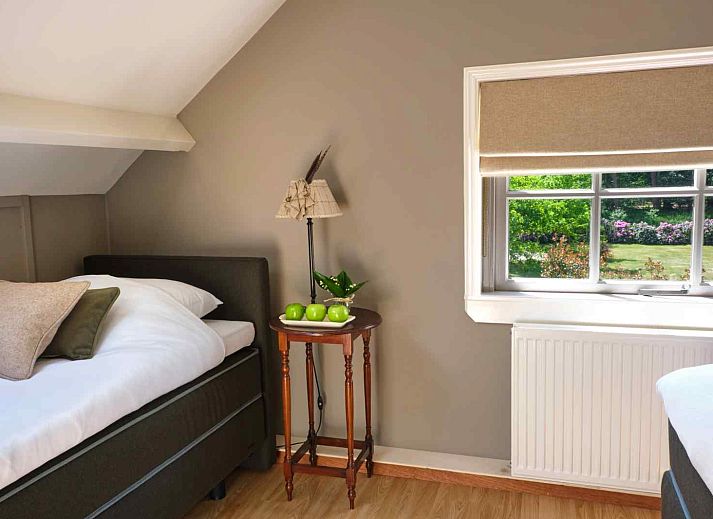 Schlafzimmer im Ferienhaus UT040 in Leersum mit ruhiger Einrichtung und Blick auf den Utrechtse Heuvelrug.