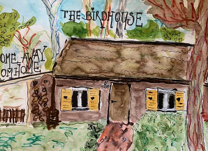 Cozy living room of a cottage in Maarn, Utrechtse Heuvelrug, with a comfortable sofa and a view of the terrace surrounded by nature.