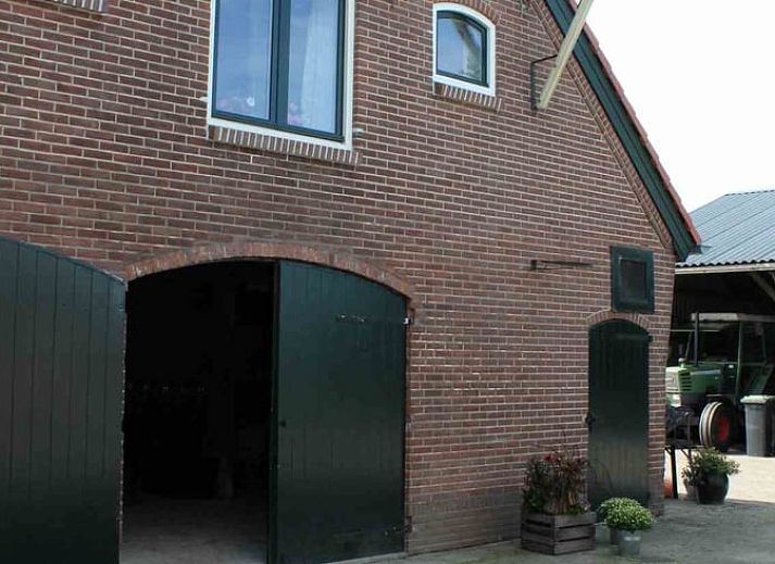 Gezellige woonkamer in Vakantiehuisje in Achterveld, Utrechtse Heuvelrug, met houten balken en comfortabele zitruimte.