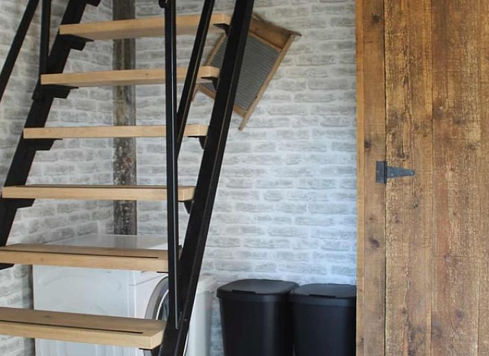 Gezellige woonkamer in Vakantiehuisje in Achterveld, Utrechtse Heuvelrug, met houten balken en comfortabele zitruimte.