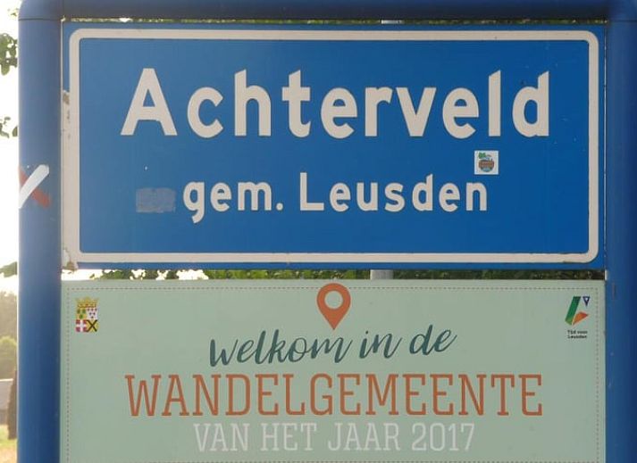 Gemuetliches Wohnzimmer von Huisje in Achterveld, einem Ferienhaus in der Utrechter Huegelkette, Utrecht, mit komfortabler Sitzecke und Holzdecke.