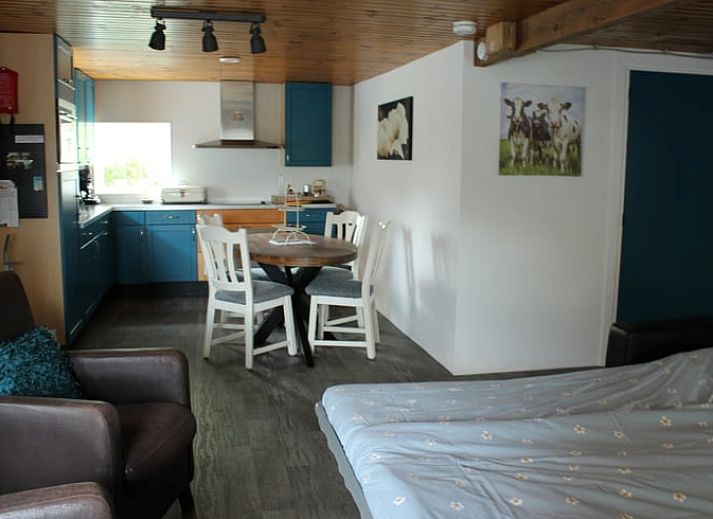 Gemuetliches Wohnzimmer von Huisje in Achterveld, einem Ferienhaus in der Utrechter Huegelkette, Utrecht, mit komfortabler Sitzecke und Holzdecke.