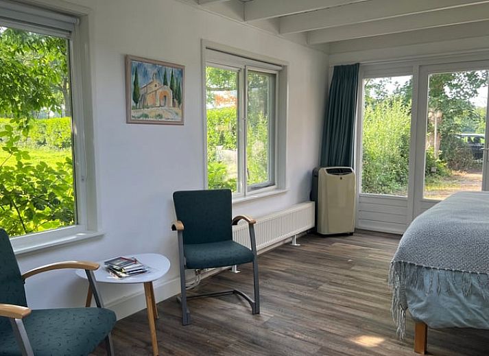 Gemuetliche Terrasse des Ferienhauses in Stoutenburg, Utrecht, mit Blick auf den Garten und bequemen Sitzgelegenheiten.