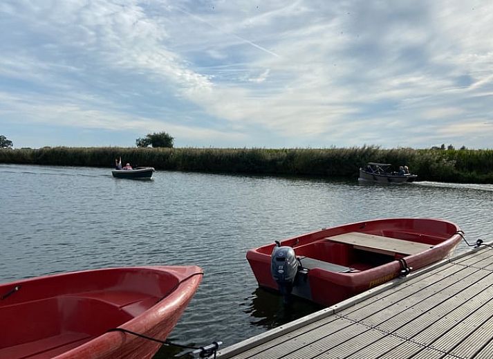Cozy indoor area of Huisje in IJsselstein, vacation home located in Utrecht, with comfortable yellow armchairs and water views.