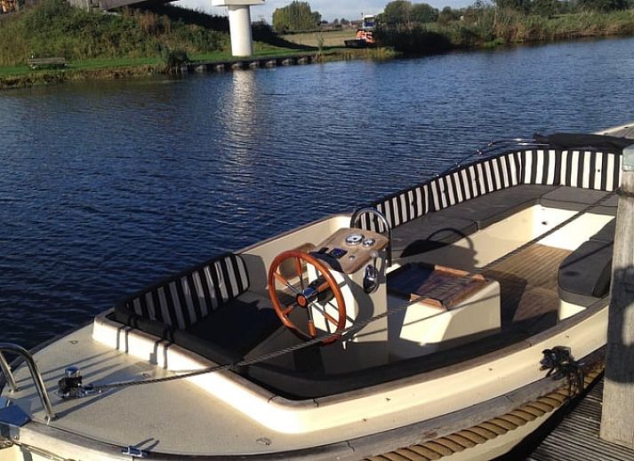 Cozy indoor area of Huisje in IJsselstein, vacation home located in Utrecht, with comfortable yellow armchairs and water views.